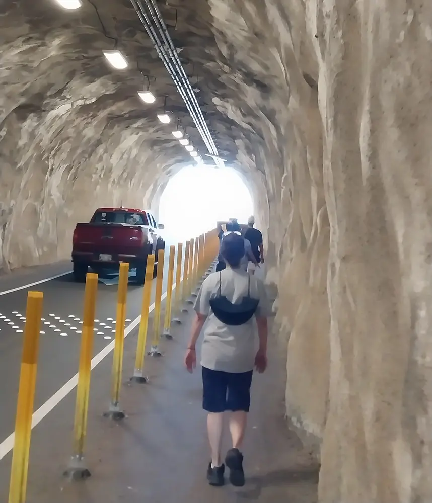 Travelers walking through the pedestrian tunnel leading toward the main trail to begin their diamond head hike