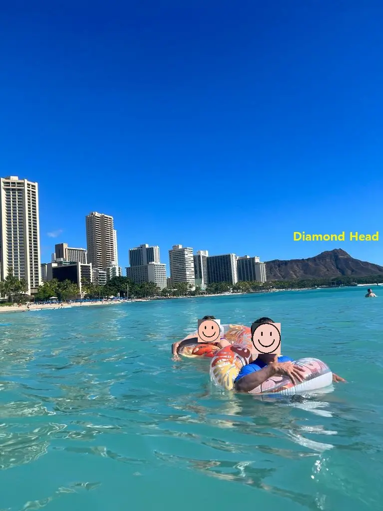 Travelers swimming and floating in the ocean with Diamond Head crater in the distance on an Oahu Hawaii first day itinerary