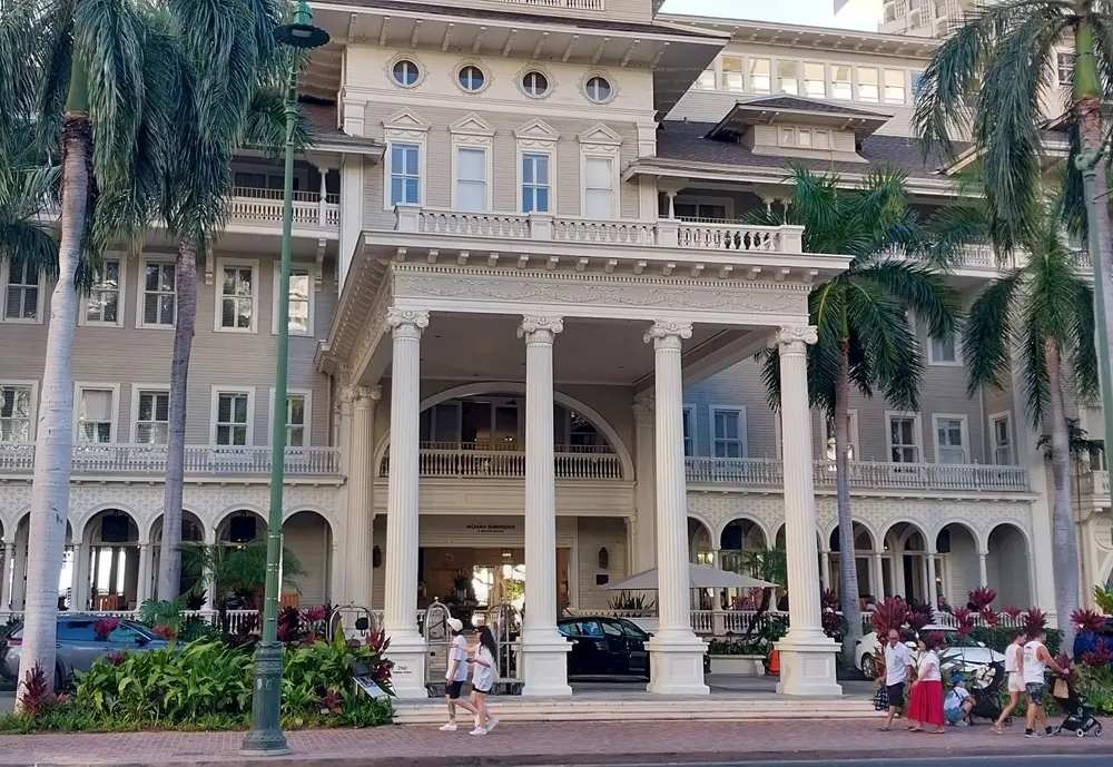 Beautiful European-style architecture and relaxed tourists walking along the streets of Waikiki on an Oahu Hawaii first day itinerary night
